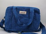 Le petit sac bleu est posé sur une surface blanche.