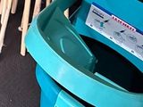 a blue toilet with a blue seat and some sticks