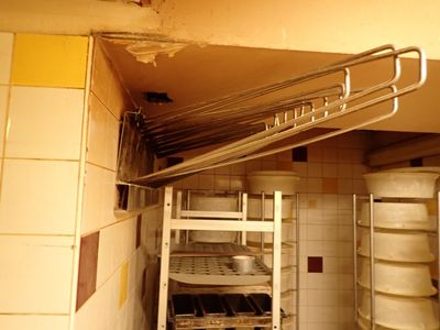 une photo d'une cuisine sale avec une pile de vaisselle