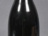 a black bottle with a red top sitting on a table