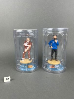 pair of figurines of a man and a woman in a glass case