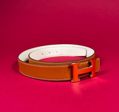 a brown and white belt on a pink background
