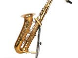 une image représentant un saxophone posé sur un pupitre, sur fond blanc