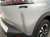 the rear end of a silver car with a sticker on it ' s bumper