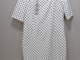 une robe à pois blancs et noirs suspendue à un cintre