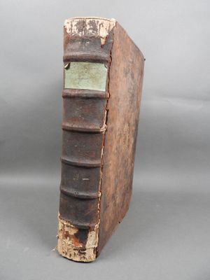 an old book sitting on top of a table next to a gray background