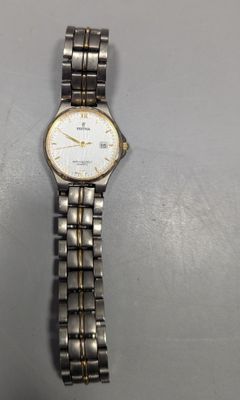 un gros plan d'une montre-bracelet posée sur une table, sur fond blanc