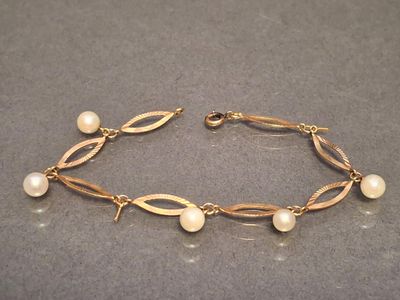 a close up of a bracelet with pearls on it