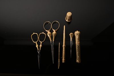five pairs of scissors that are on display in a dark room