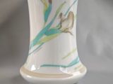 a white vase with a picture of a woman and a bird on it