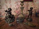 trois figurines posées sur une table, avec un tableau accroché au mur derrière elles