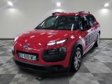 La Citroën rouge est garée sur le sol à damier du garage.