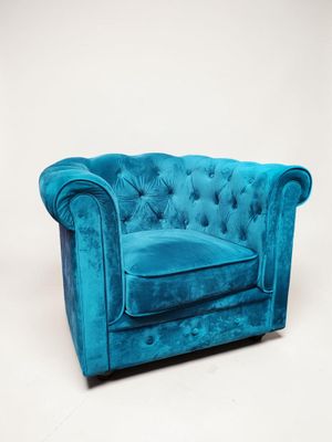 fauteuil Chesterfield en velours bleu, avec accoudoirs et dossier capitonnés