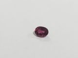 an oval shaped pink sapphire stone on a white surface