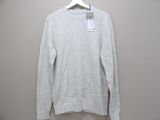 the white sweater is hanging on a hanger on the wall