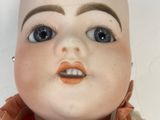 a close up of a doll ' s head with a scarf around it