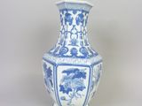 un vase bleu et blanc posé sur une surface blanche