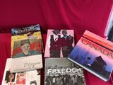 Plusieurs livres sont posés sur un tissu rouge, sur un canapé rouge.