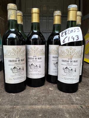 quatre bouteilles de vin rouge sont alignées sur une table