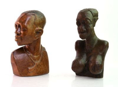 two sculptures of a woman and a man on a white surface