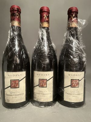 three bottles of wine wrapped in plastic on a table