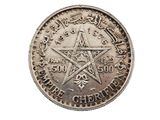 une vieille pièce d'argent sur laquelle figure un pentagramme