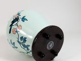 a vase with a bird on it sitting on a table
