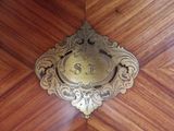 a clock that is on a wooden table in the room