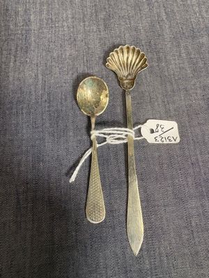 deux cuillères en argent et une cuillère à laquelle est attachée une étiquette