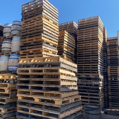 plusieurs piles de palettes en bois empilées les unes sur les autres