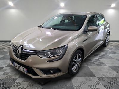 La voiture beige est garée dans le garage, sur le sol à carreaux.