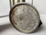a silver cup with a handle on a white table
