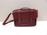 a close up of a red leather bag on a white surface