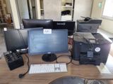 a desk with a computer, printer, and other electronics on it