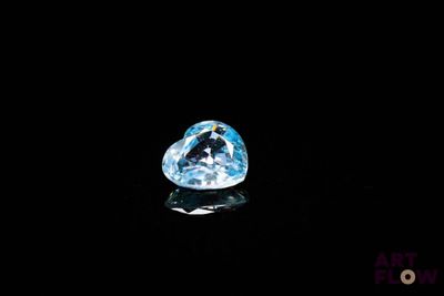 gros plan d'un diamant bleu sur une surface noire