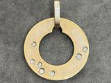 a close up of a gold plated pendant with diamonds on it