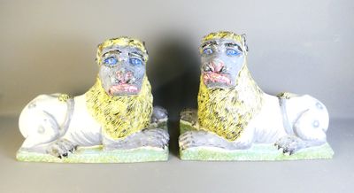 two figurines of lions are sitting on the ground