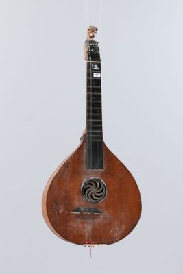 a guitar hanging from a string on a white wall