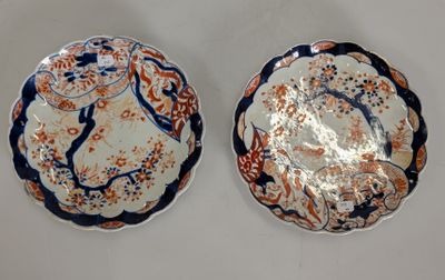 two plates with designs on them sitting on a white surface