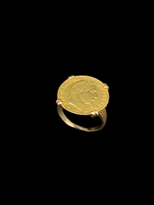 a close up of a gold ring with a coin on it
