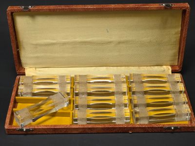 un coffret en bois contenant des couteaux, posé sur une surface noire