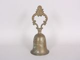 an old bell with a decorative design on it on a white surface