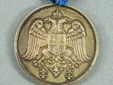 an old medal with a blue ribbon around it and a gold eagle on it