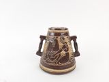 a brown vase with a design on it on a white surface