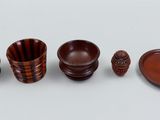 a group of wooden bowls and plates on a white surface