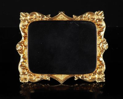 un cadre doré sur fond noir, posé sur une surface noire