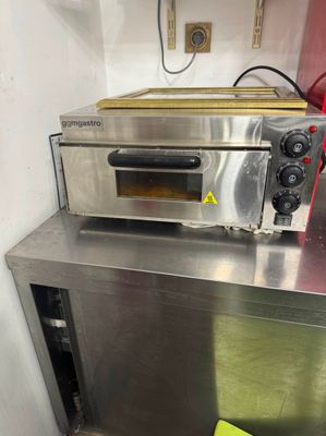 a small oven sitting on top of a metal counter