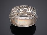 gros plan d'une bague en argent sur une surface noire
