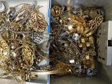a box full of gold and silver jewelry on a table
