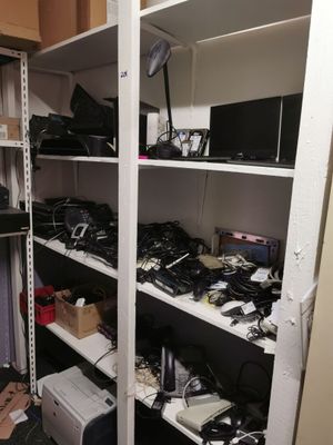 a closet with a lot of electronics on the shelves